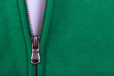 Close up of Zipper  partly open. On a green backgroundの写真素材