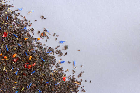 spilled tea with flowers and fruits on a gray background. empty space for textの写真素材