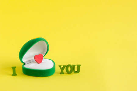 green box for jewelry with a heart inside and words I love you on a yellow backgroundの写真素材