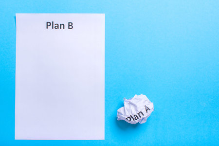 Crumpled paper Plan A and clean sheet Plan B on a blue backgroundの写真素材