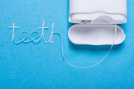 Word teeth of dental floss on a blue backgroundの写真素材