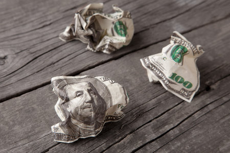 Crumpled dollars on an old wooden table