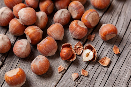 Heap Hazel and two nuts with  broken shell on an old wooden table.
