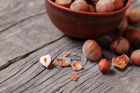 Heap Hazel and nuts with  broken shell on an old wooden table.の写真素材