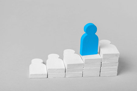 Up the career ladder on the heads of colleagues and subordinates. Achieving the goal of high office at any cost. The concept. Wooden colored people and one leaderの写真素材