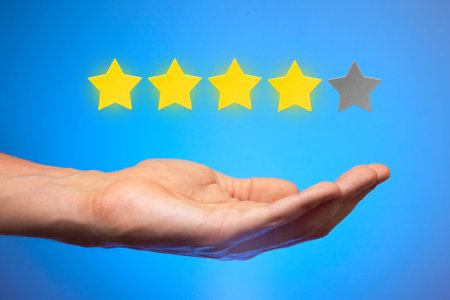 Four golden yellow stars out of five. Man holds star on the palm of his hand, puts rating, reviews....