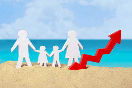 Family from dad, mom, son and daughter on the sand near the sea and arrow graphics up. The concept of growing tourists in the summer tourist seasonの写真素材