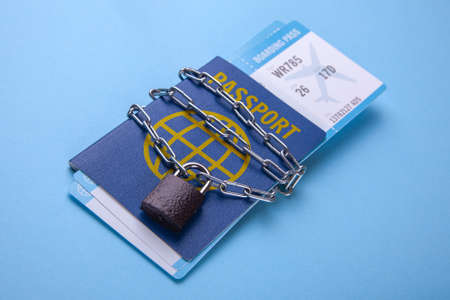 The passport is locked. Prohibition of entry and exit from the country. Lock with chain on the passport and plane ticketsの写真素材