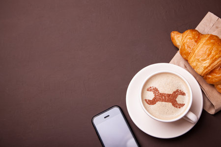 Cup of coffee with  wrench on the foam. I like a coffee break with  croissant. Repair service...