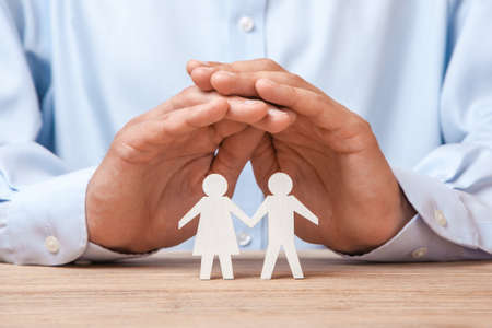 Medical or travel insurance. Man covers his family with man and  woman.の写真素材