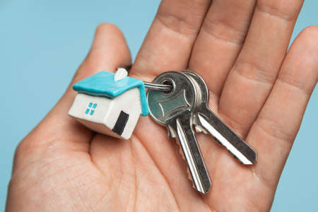Keys and key ring house on hand. Concept of buying a house, renting, mortgage, giftの写真素材