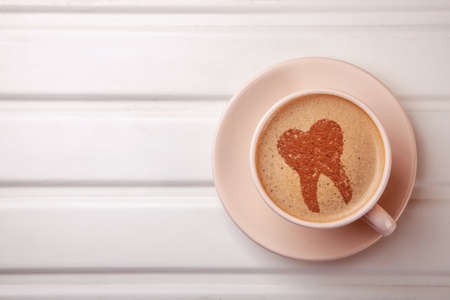 Cup of coffee with a tooth on foam.の写真素材