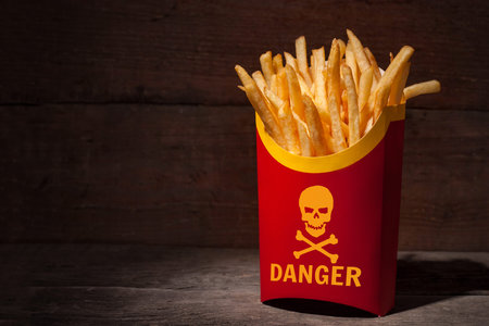 French fries in red paper packing on a wooden table