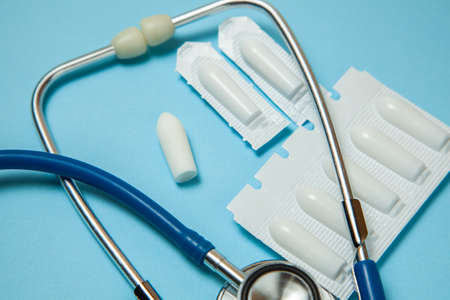 Suppository for anal or vaginal use and stethoscope. Candles for treatment of hemorrhoids, temperature, thrush, inflammationの写真素材