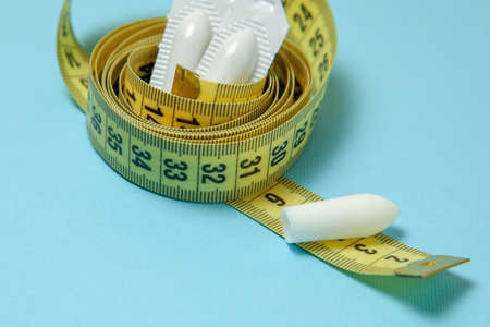 Suppository for anal or vaginal use and yellow measuring tape. Candles for the treatment of obesity, extra weight, for weight lossの写真素材
