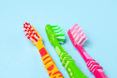 Used dirty toothbrushes on blue background. How to choose toothbrush