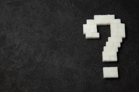 Question mark made of sugar cubes on a black background. How to find out if you have diabetes?