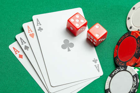 Concept of gambling in casino, sports poker. Game cards with dice and colored chips sleep green game tableの写真素材