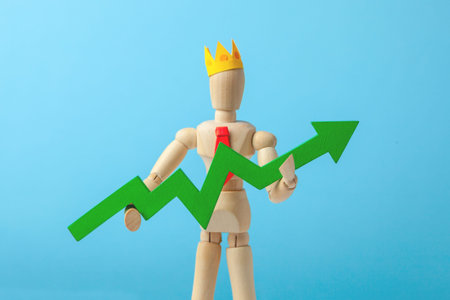 Businessman in tie and crown holding green arrow up on blue background. Good manager makes growth of...