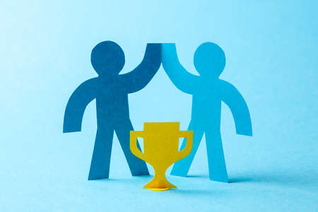 Successful business team winner holds gold cup in his hands. Team building. Leader and Workers Reach the Goalの写真素材
