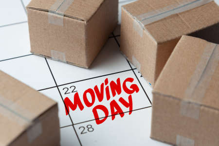 Moving day on the calendar is written in red. Calendar with a note with cardboard boxesの写真素材
