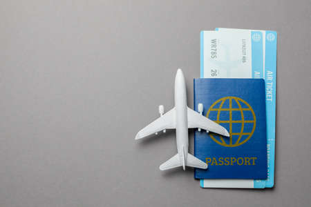 Tickets for plane and passport with model of passenger plane on gray background. Copy space for text.の写真素材