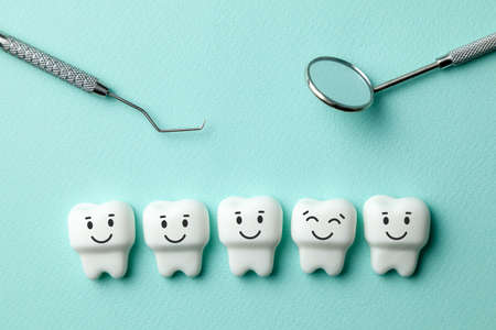 Healthy white teeth are smiling on green mint background and dentist tools mirror, hookの写真素材