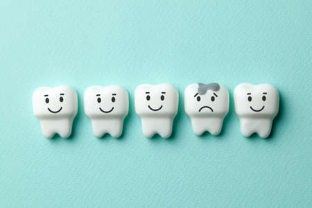 Healthy white teeth are smiling and tooth with caries is sad on green mint backgroundの写真素材