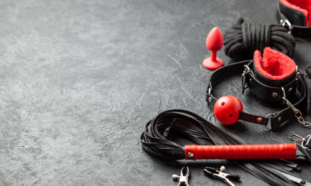 Set of erotic toys for BDSM. The game of sexual slavery with handcuffs, whip, gag and leather straps. Intimate games. Copy space for textの写真素材