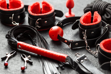 Set of erotic toys for BDSM. The game of sexual slavery with handcuffs, whip, gag and leather...