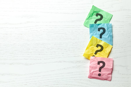 Question mark on colored office note paper. Copy space for text