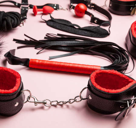 Set of erotic toys for BDSM. The game of sexual slavery with handcuffs, whip, gag and leather straps. Intimate gamesの写真素材