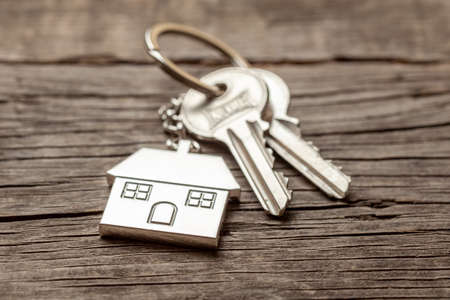 Keychain house with keys on old wooden boardsの写真素材