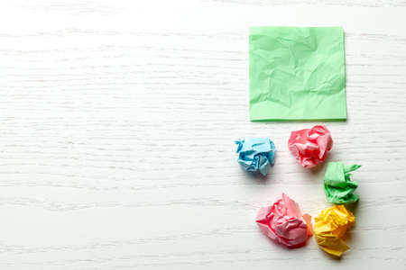 Colored wrinkled note paper on white wooden table. Copy space for textの写真素材
