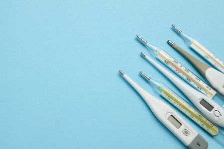 Medical thermometers glass and electronic on blue background. Copy space for text