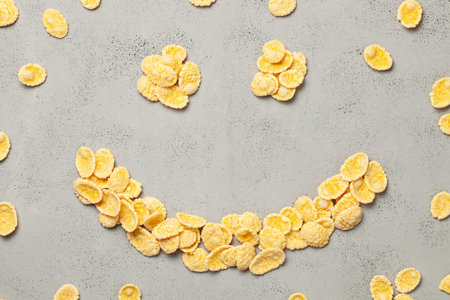 Yellow flakes in the shape of smiling face on blue background. I like breakfast cereal