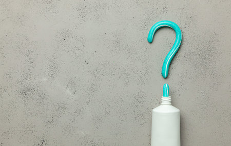 Toothpaste in the shape of a question mark. Concept of how to choose a toothpaste or dentist. Copy...