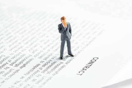 Businessman in a suit and tie ponders contact. Conclusion of an agreement between the companies and the employee.の写真素材