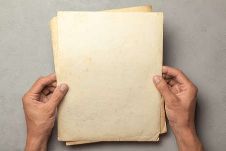 Old photo in the hands of man. Empty template for picture, mock-up. Gray background.の写真素材