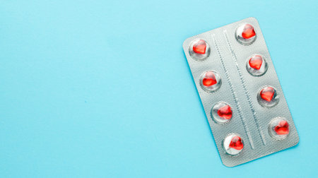Love pills. Blister pack with red heart shaped pills. Tablets for lovers or potency. Green...