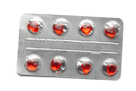 Love pills. Blister pack with red heart shaped pills. Tablets for lovers or potency. Isolated on...
