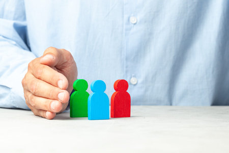 Hiring employees. How to choose a good employee leader. Man in a shirt holds figures in his hands....