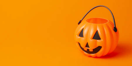 Halloween. Pumpkin candy basket on an orange backgroundの写真素材