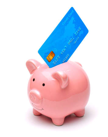 Pink piggy bank and credit cards in a stack isolated on white background. How to save money on a credit cardの写真素材
