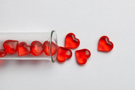 Hearts and test tube. Baby from tube vitro glass. Artificial insemination, IVF. Gray background