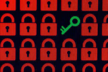 Key as a symbol of access or hacking of open personal information. Red pixel locks and a green key on a black background, close-up.の写真素材