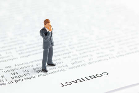 Businessman in a suit and tie ponders contact. Conclusion of an agreement between the companies and the employeeの写真素材