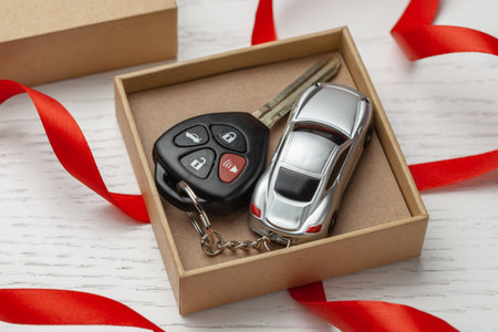 Car keys with remote control security and car key chain red ribbon and gift box.の写真素材