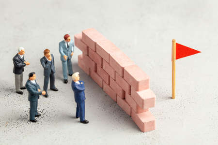 On the way to the goal of businessman, large wall as a symbol of problems or tasks to solveの写真素材