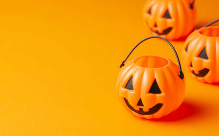 Halloween. Pumpkin candy basket on an orange background.の写真素材